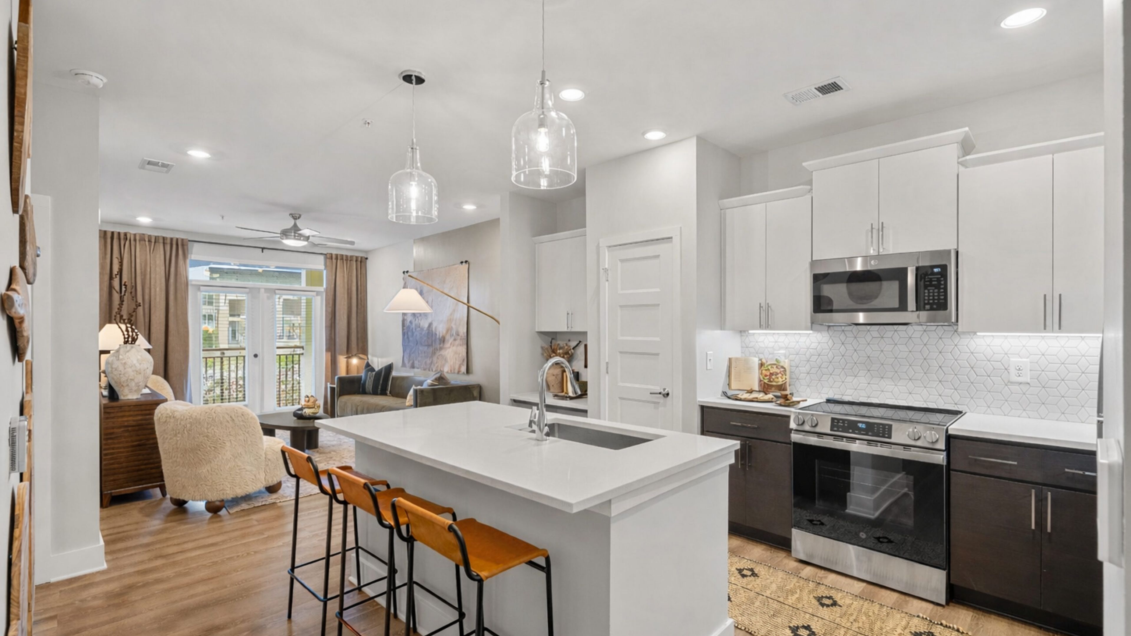 Hawthorne at Holbrook apartment kitchen area with wrap around kitchen island, stainless steel appliances, and ample cabinet storage